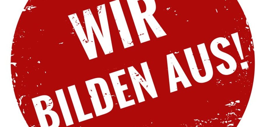 Ein roter Stempel mit der Aufschrift: Wir bilden aus!