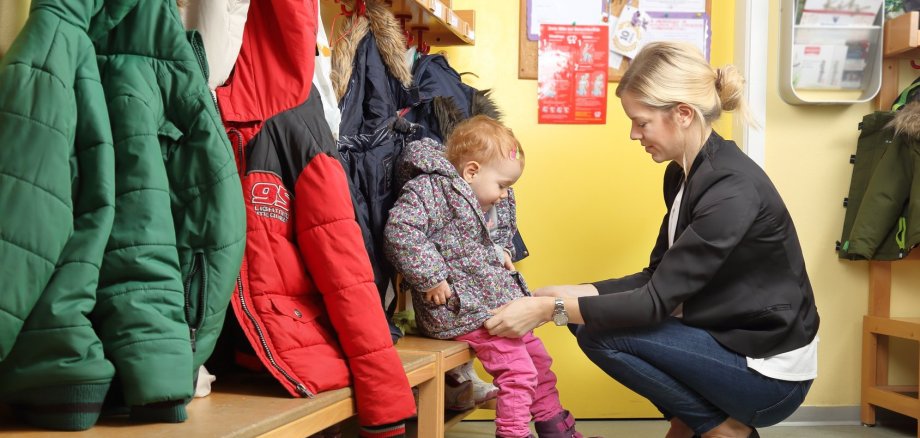 Mutter holt Kind von Kita ab.
