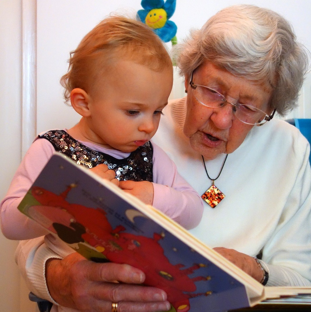 Eine Großmutter liest einem Kind vor.