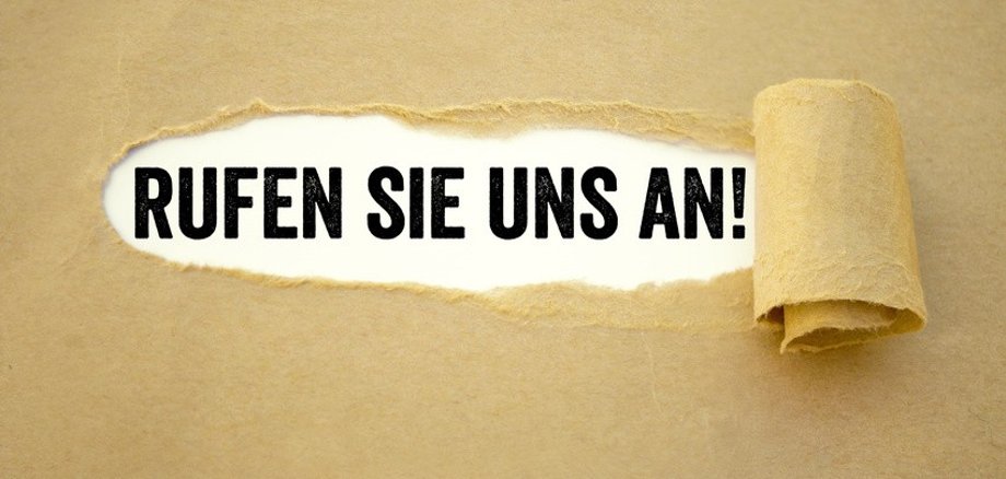 Abgerissenes Papier mit der Aufschrift: Rufen Sie uns an!