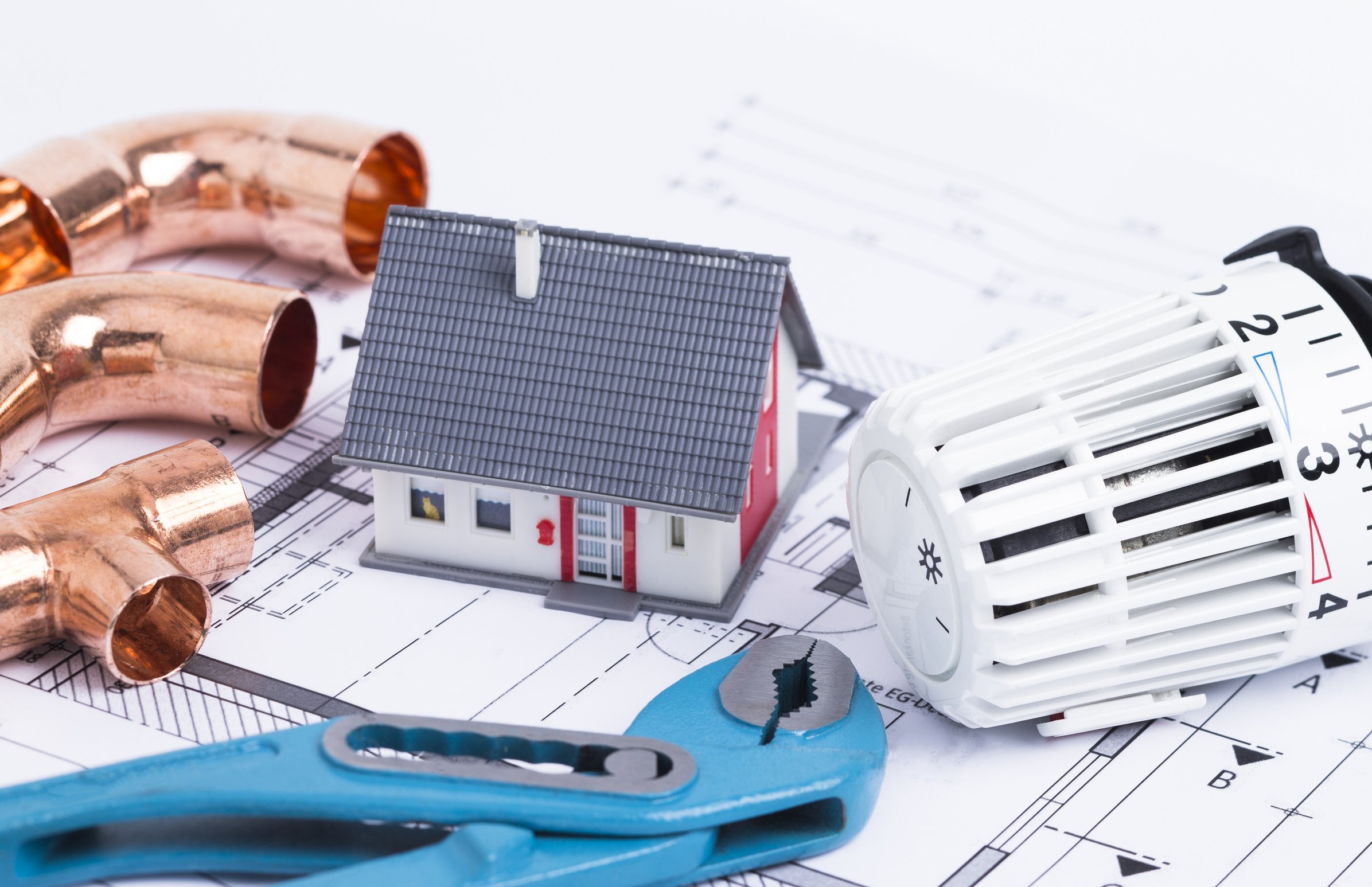 Ein Haus, Rohre und ein Heizungsregler.