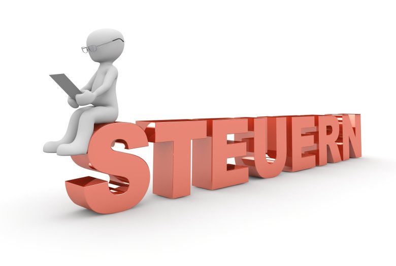 Ein Männchen sitzt mit dem Laptop auf großen Buchstaben.