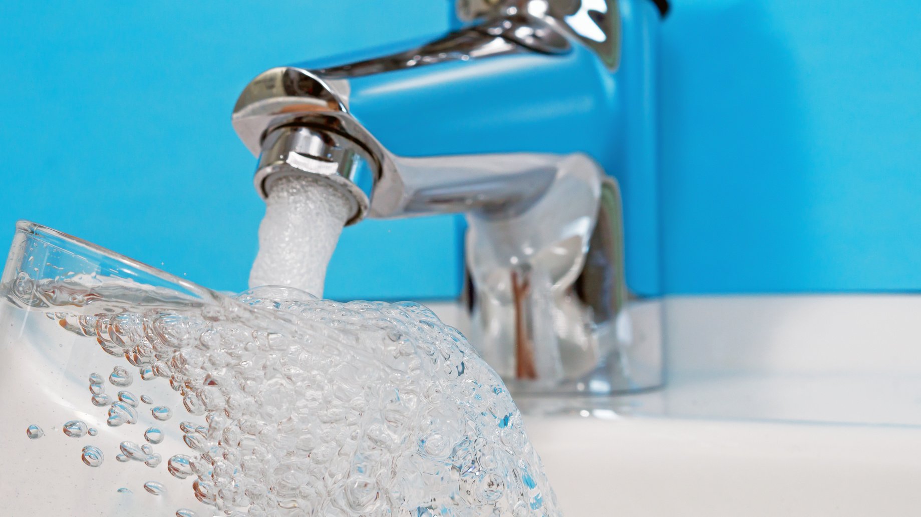 Ein Wasserhahn, aus dem ein Schwall Wasser kommt.