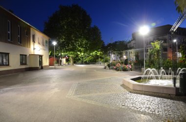 Der weitläufige Bahnhofsvorplatz am Bahnhof mit Laternenbeleuchtung.