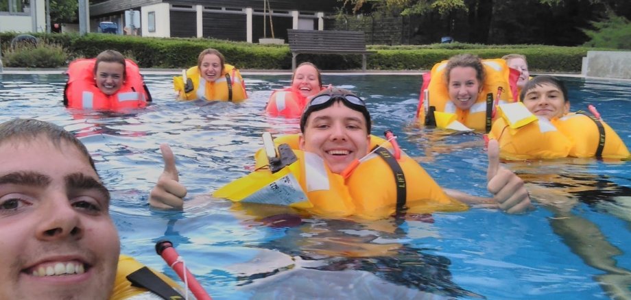 Mitglieder des DLRG testen im Wasser neue Schwimmwesten.