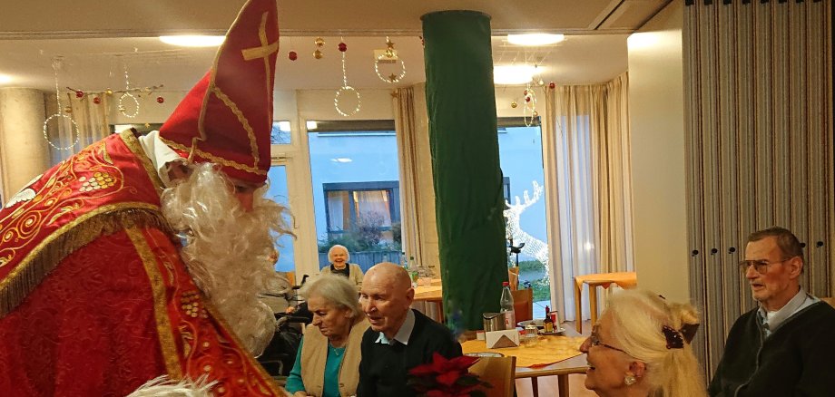 Bürgermeister Seitz als Nikolaus verkleidet übergibt Geschenke.