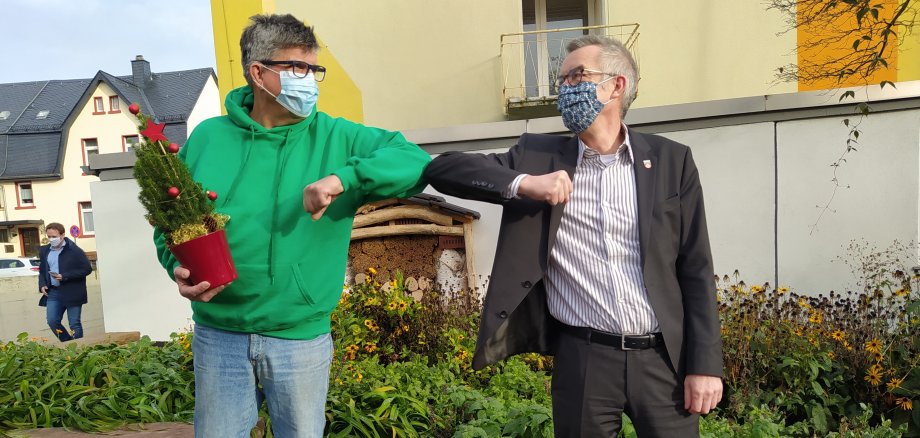 Ewald Koster und Franz Jirasek mit Maske machen einen Ellenbogen-Gruß.
