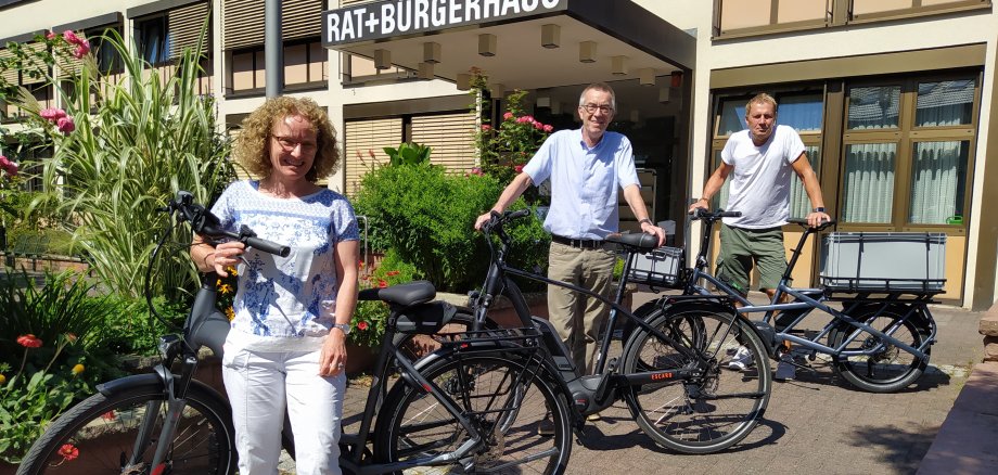 Franz Jirasek mit zwei Mitarbeiter/innen und den neuen E-Bikes vor dem Rathaus.