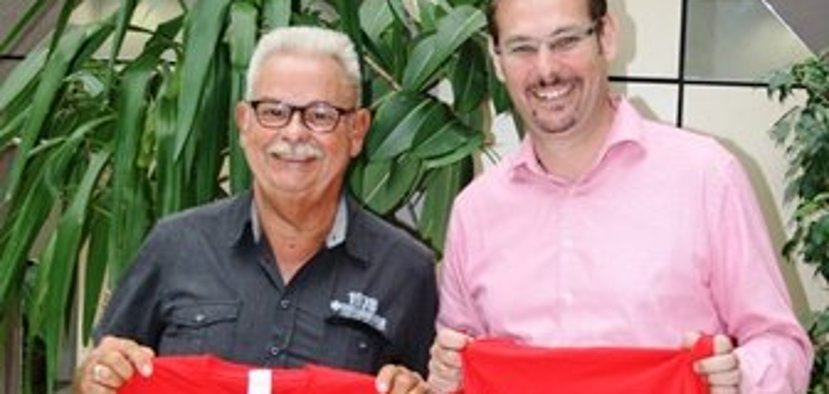 Mister Ferienspiele Didi Dehyle mit Bürgermeister Seitz. Sie halten rote Shirts in der hand.