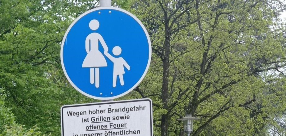 Blaues Gehweg-Schild mit weißen Fußgängern.