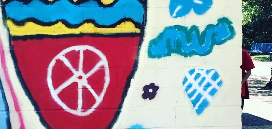 Das Krifteler Wappen als Graffiti an einer Wand der Wetterschutzhütte.