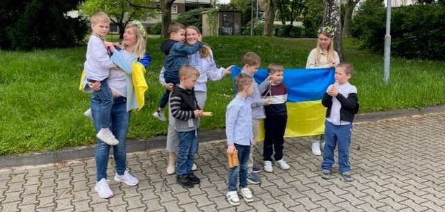 Kinder aus der Ukraine halten die Flagge ihres Heimatlandes.