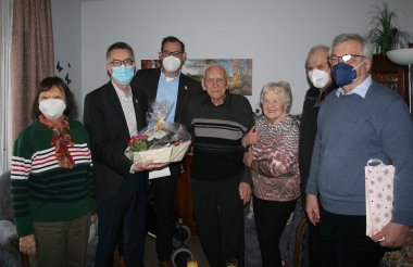 Gerhard Jaeger mit Frau Evelin und Gratulanten im Wohnzimmer.