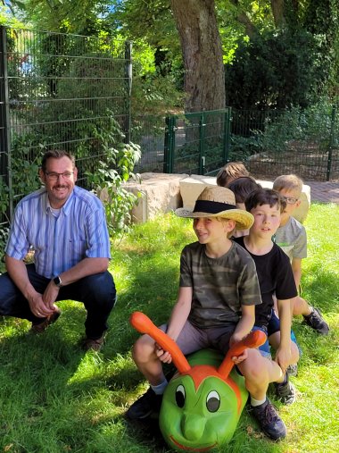 Bürgermeister Seitz mit Kindern auf einem Spielplatz.