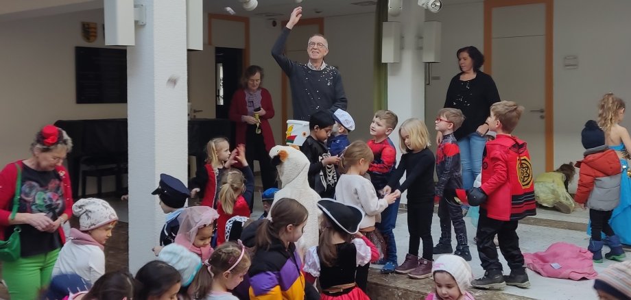 Franz Jirasek schmeißt Süßes in die Kindermenge.