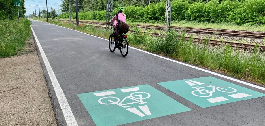Eine Fahrradfahrerin auf einer mit großen Symbolen versehenen Schnellstraße - nur für Fahrradfahrer.