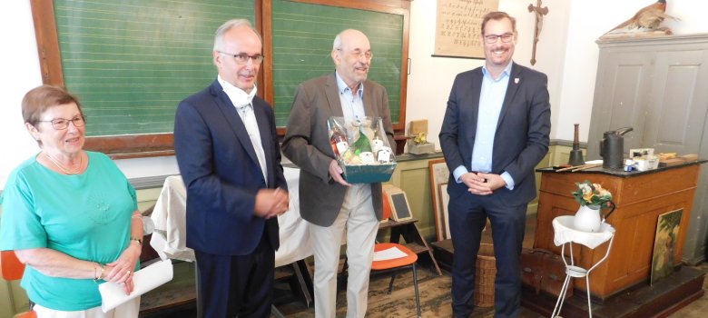 Schulmuseumsleiter Wolfgang Janecke mit Geschenk und Promis bei der Raritätenvorstellung im Museum.