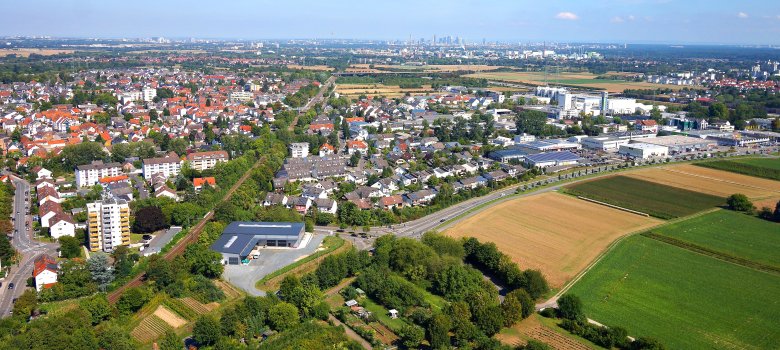 Eine Luftansicht von Kriftel - Am Horizont die Frankfurter Skyline, die Häuser von Kriftel und vorne das Hochfeld.