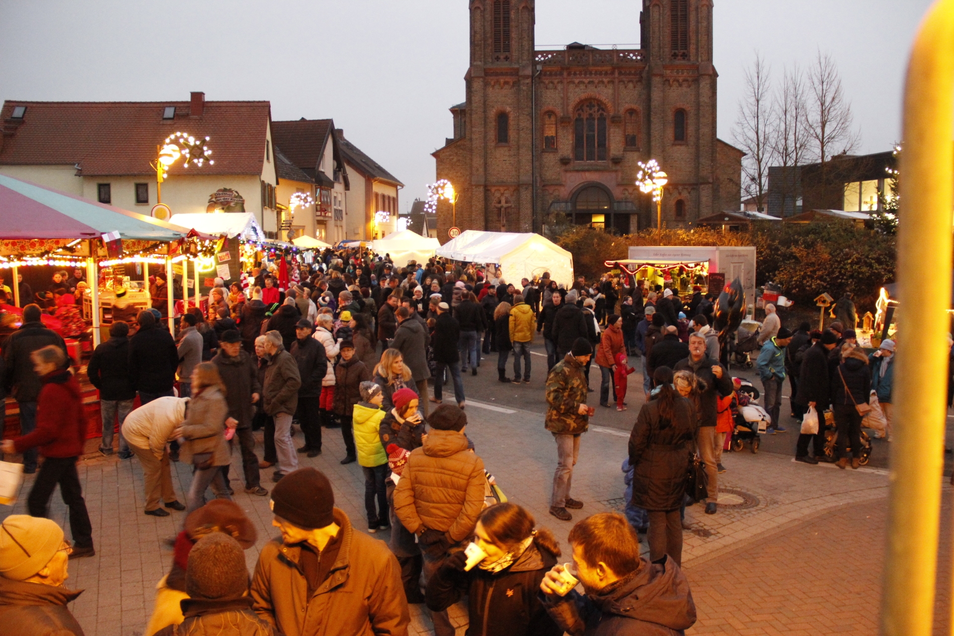 Viele Menschen an den Buden vor der Kirche.