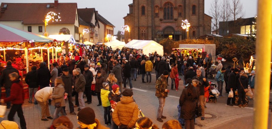 Viele Menschen an den Buden vor der Kirche.