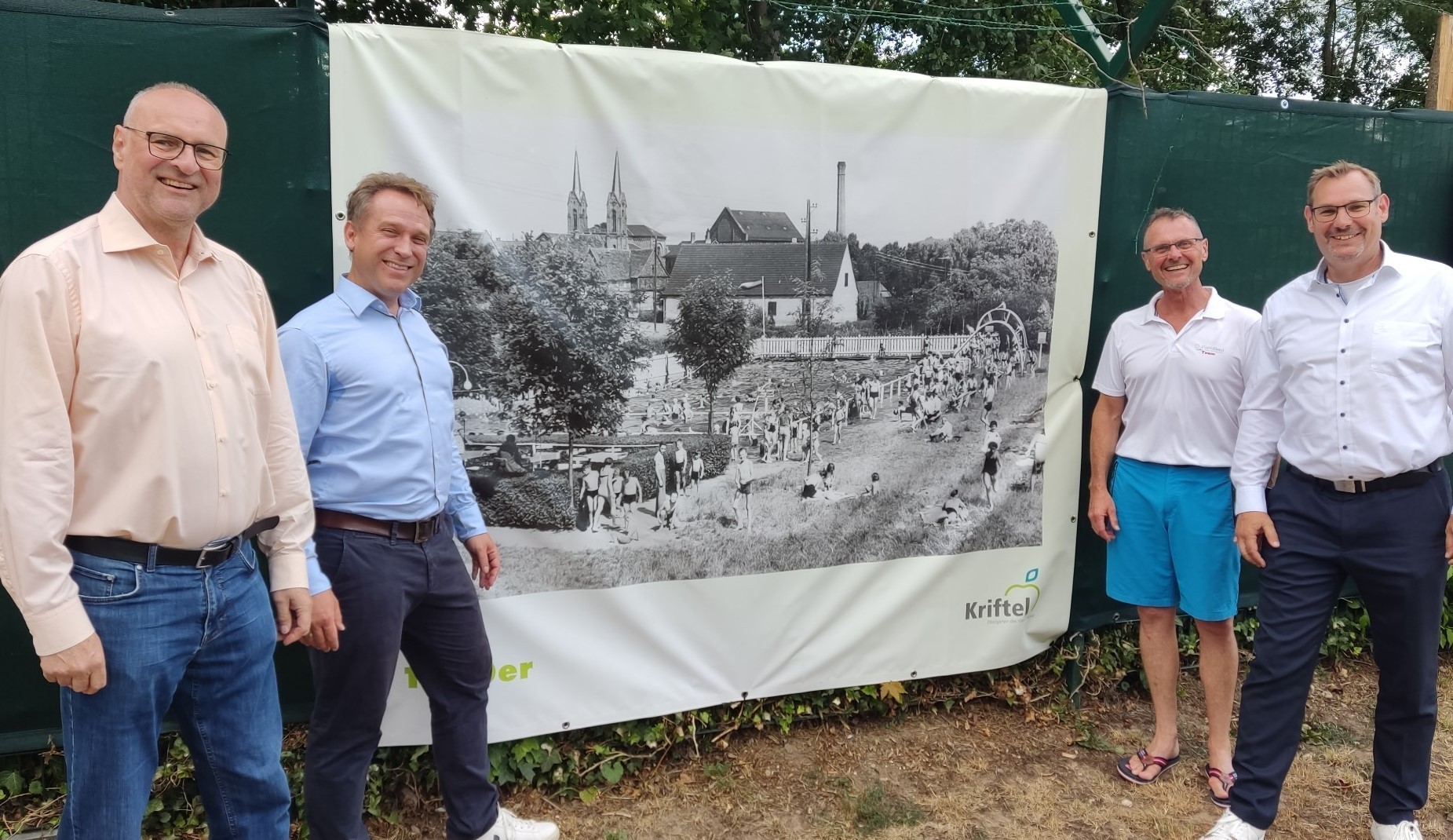 Rathausspitze neben historischem Bild.