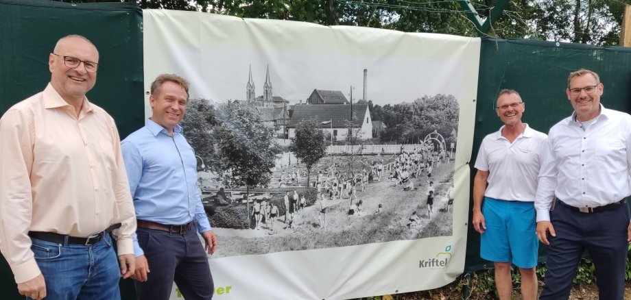 Rathausspitze neben historischem Bild.