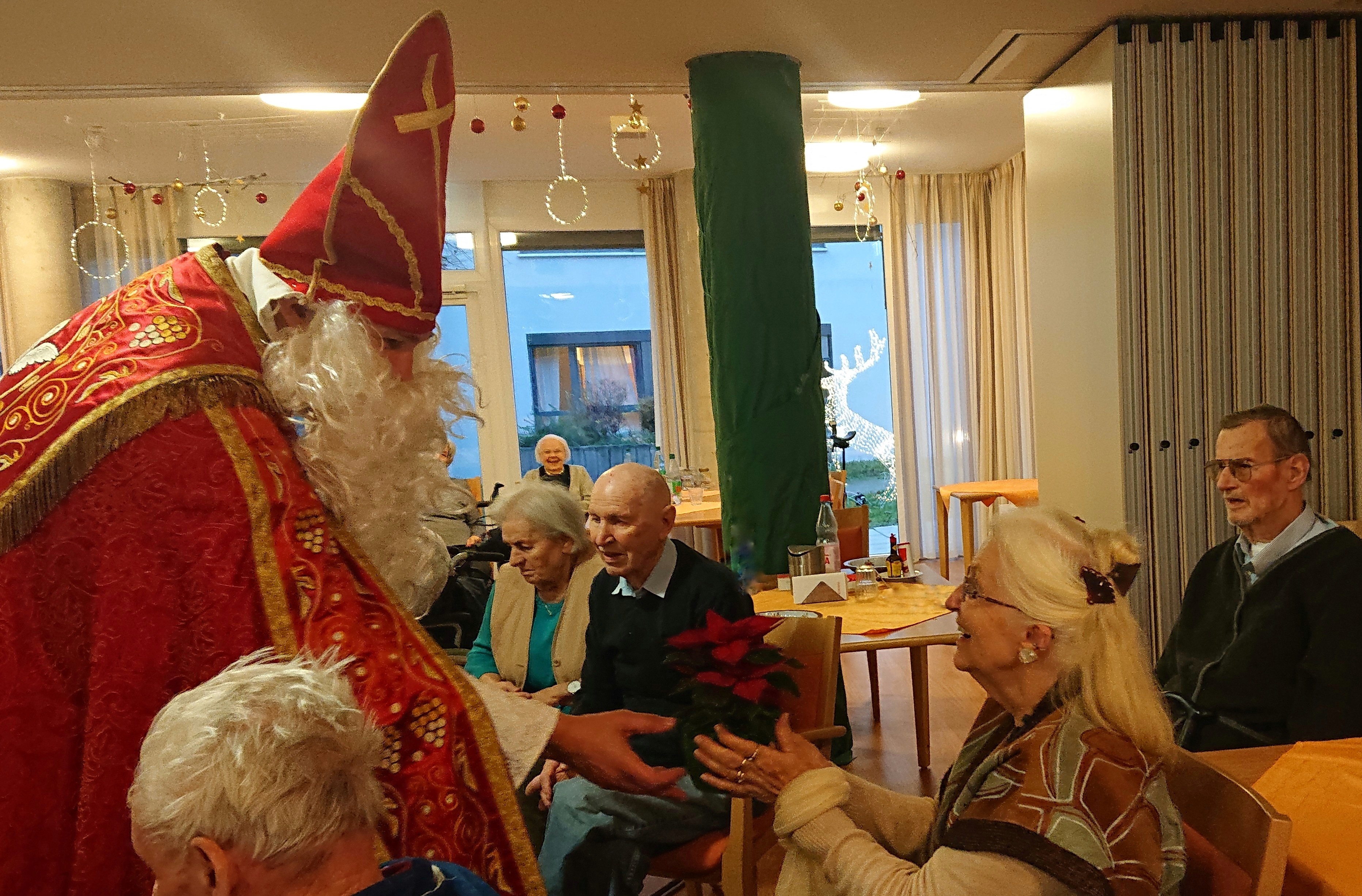 Bürgermeister Seitz als Nikolaus verkleidet übergibt Geschenke.