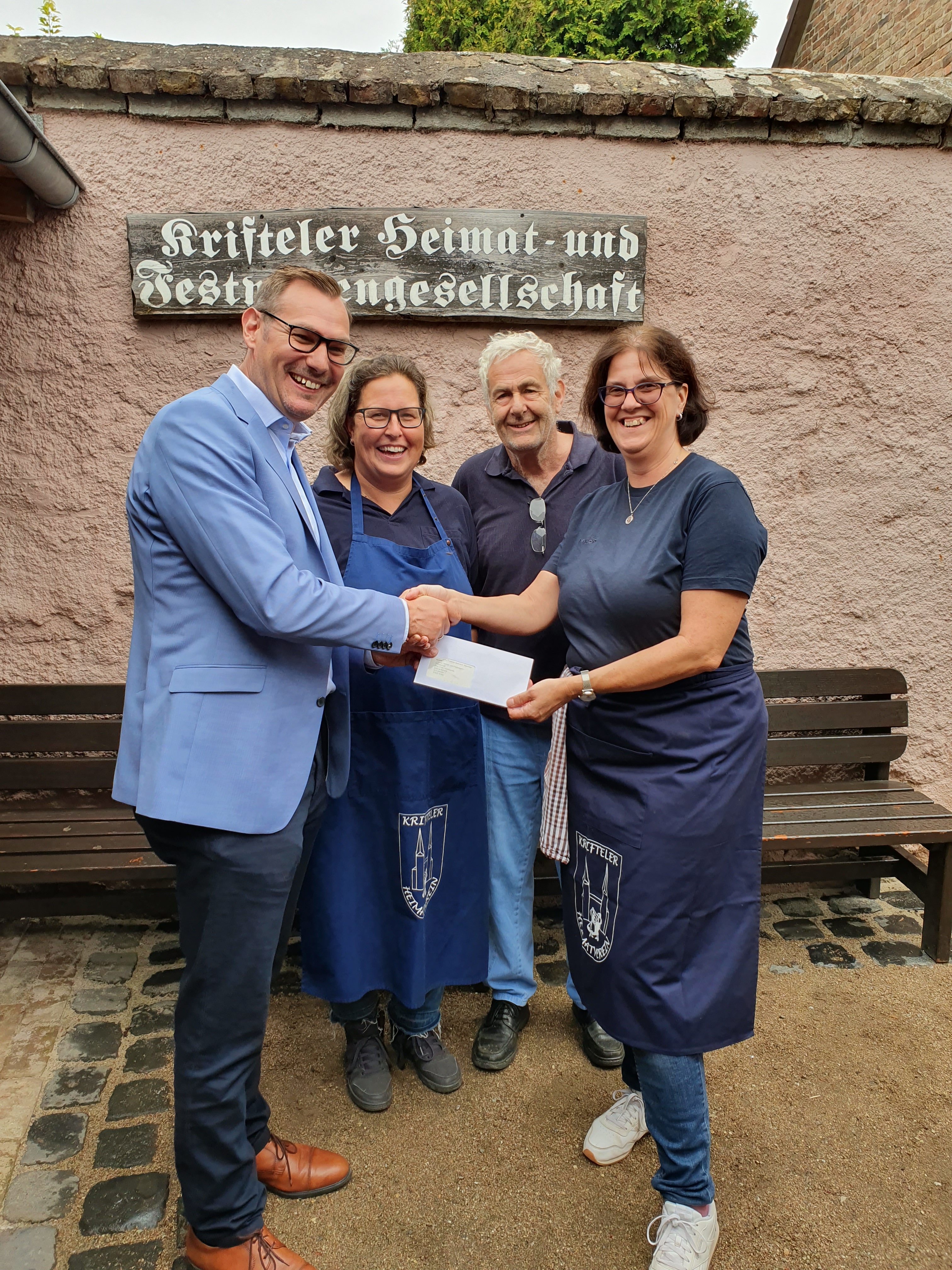 Bürgermeister Seitz übergibt der Vorsitzenden einen Scheck.