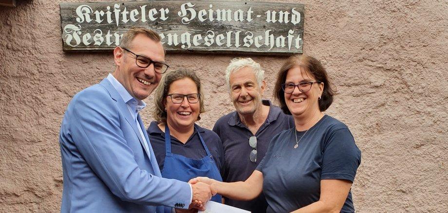 Bürgermeister Seitz übergibt der Vorsitzenden einen Scheck.