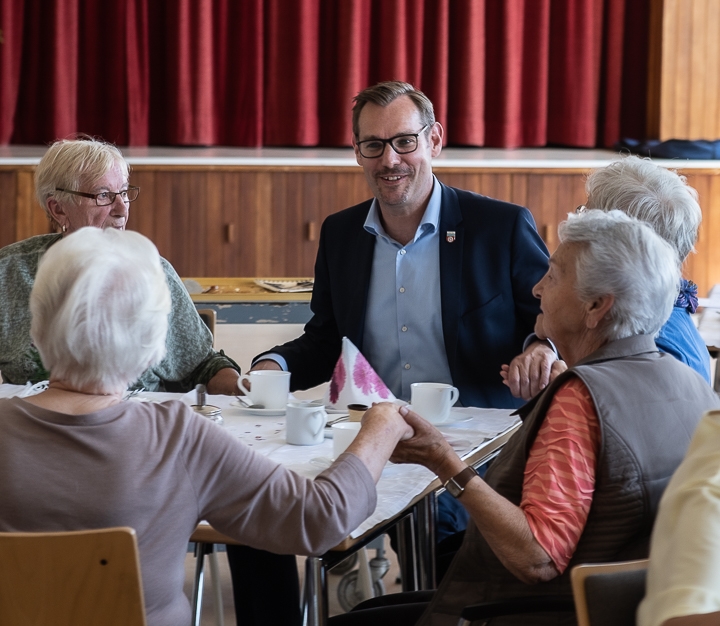 Bürgermeister Seitz schunkelt mit Senioren zur Musik.