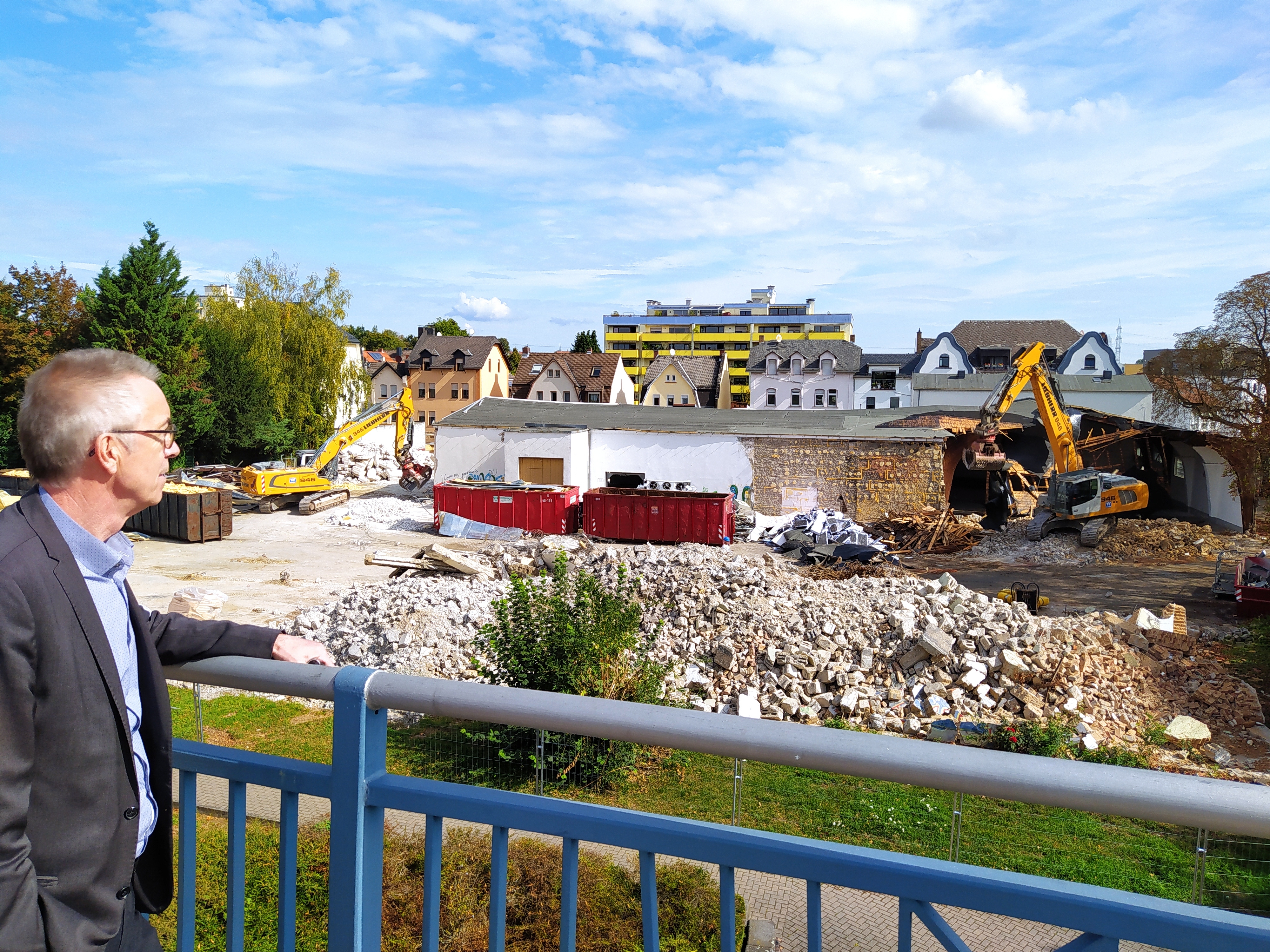 Der Erste Beigeordnete Franz Jirasek schaut von der Eisenbahnbrücke auf die Abrissarbeiten auf dem ehemaligen ROWG-Gelände.