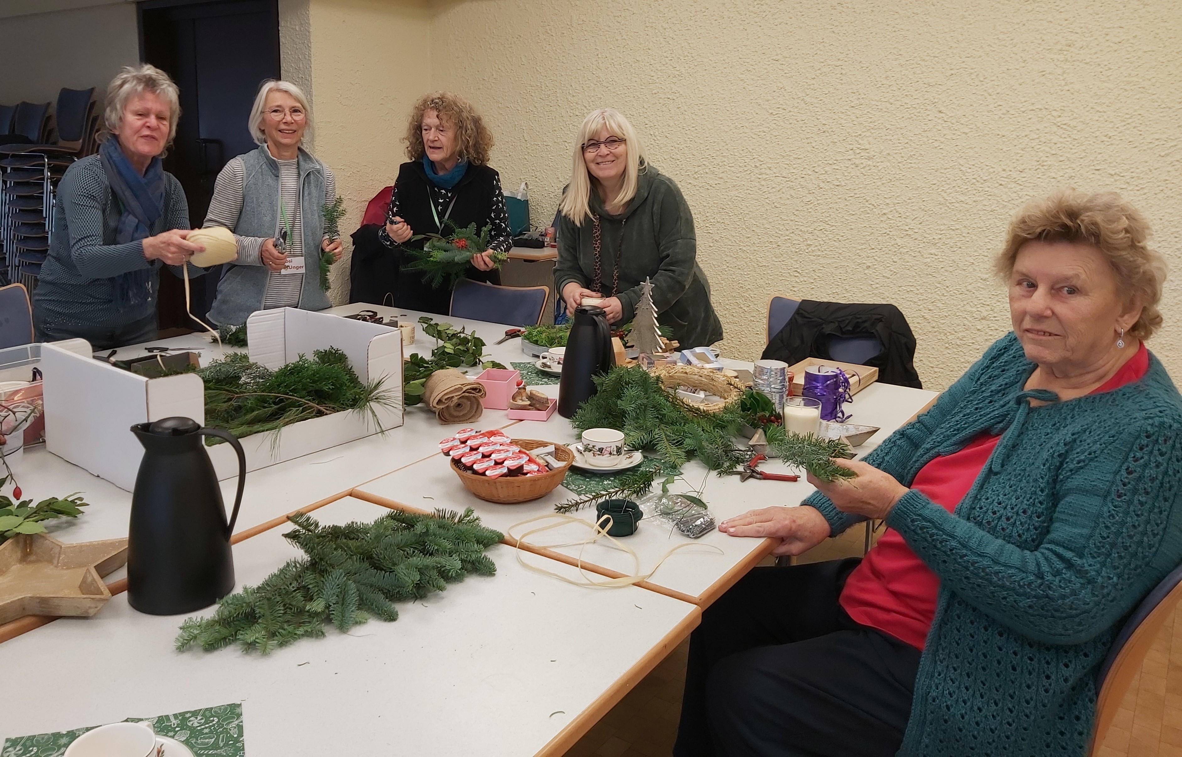 Frauen mit Bastelmaterialien an einem Tisch.