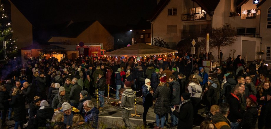 Der Kirchplatz voller Menschen am Glühweinabend.