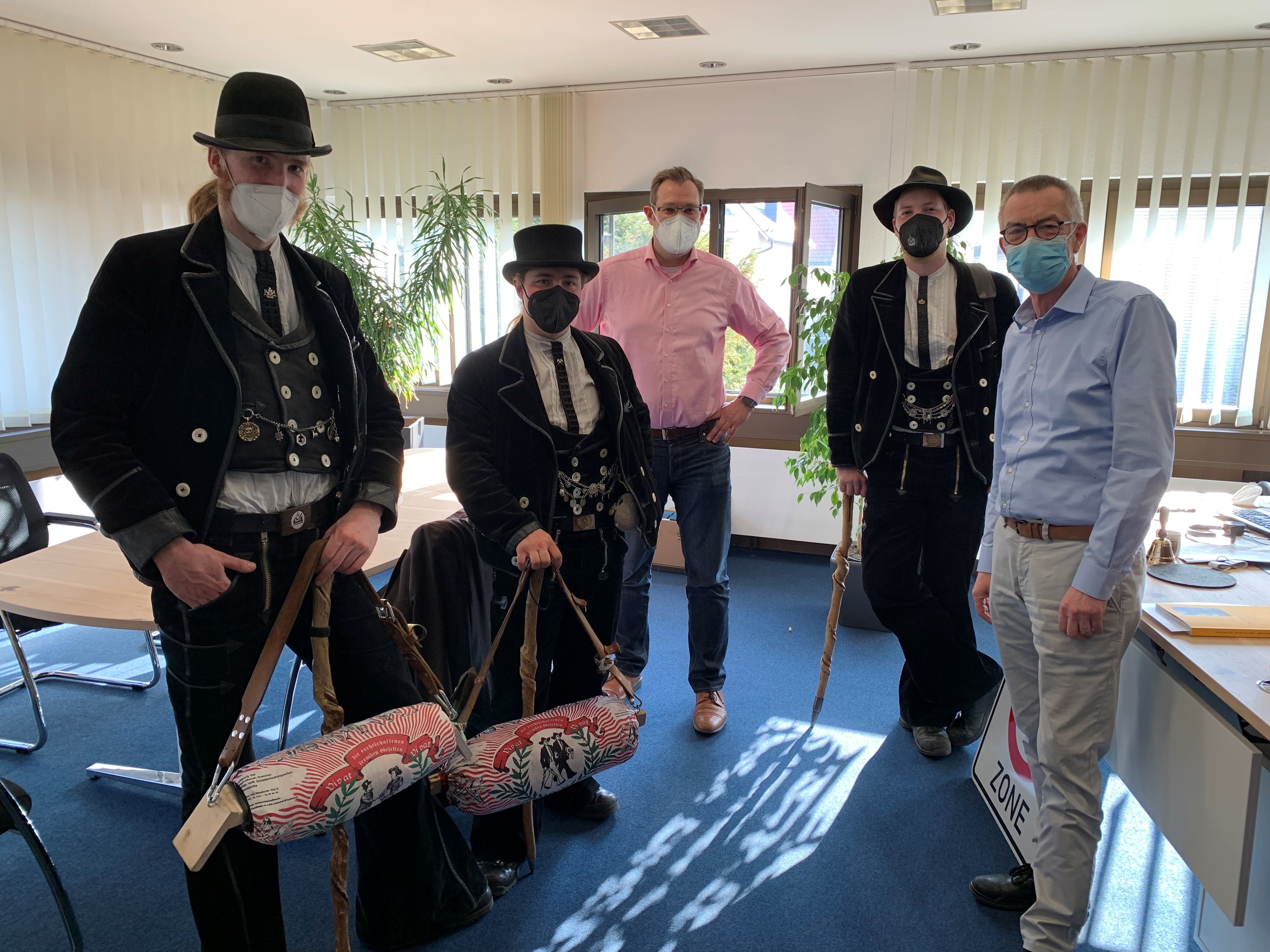 Drei Zimmerleute in traditioneller Tracht im Büro von Bürgermeister Seitz.