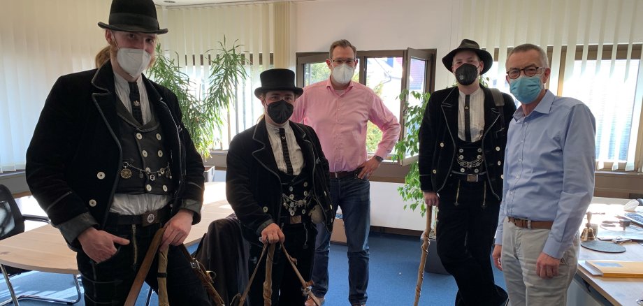 Drei Zimmerleute in traditioneller Tracht im Büro von Bürgermeister Seitz.