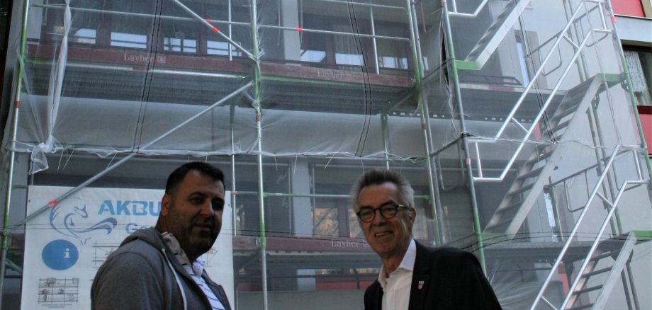 Franz Jirasek mit dem Bauleiter vor dem Josef-Wittwer-Haus. Die Balkone sind eingerüstet.