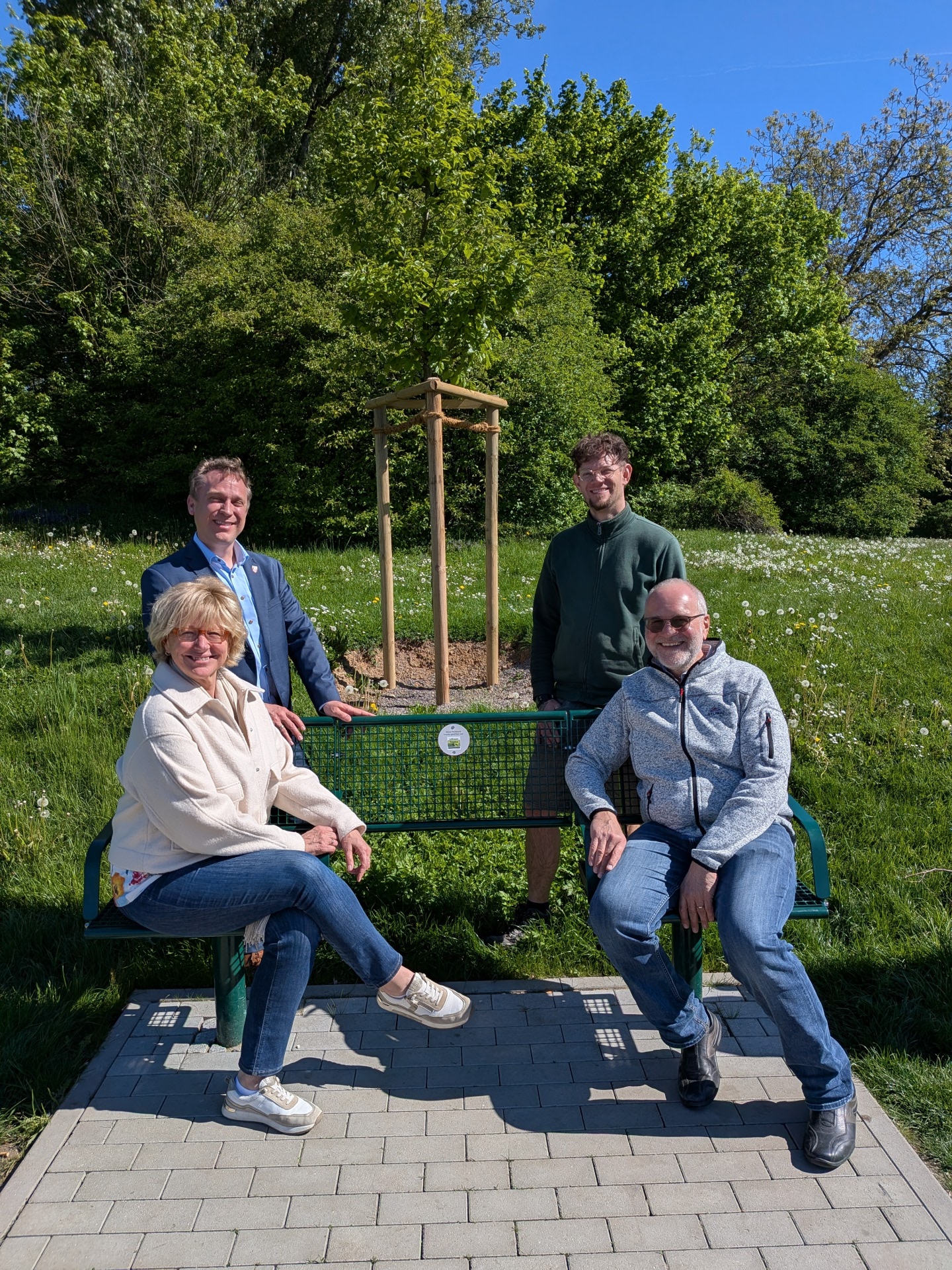 Die Spender auf der Bank, im Hintergrund der Baum.