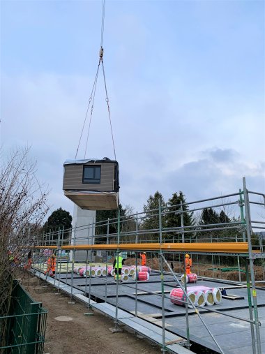 Ein Holzmodul wird per Kran "eingesetzt".
