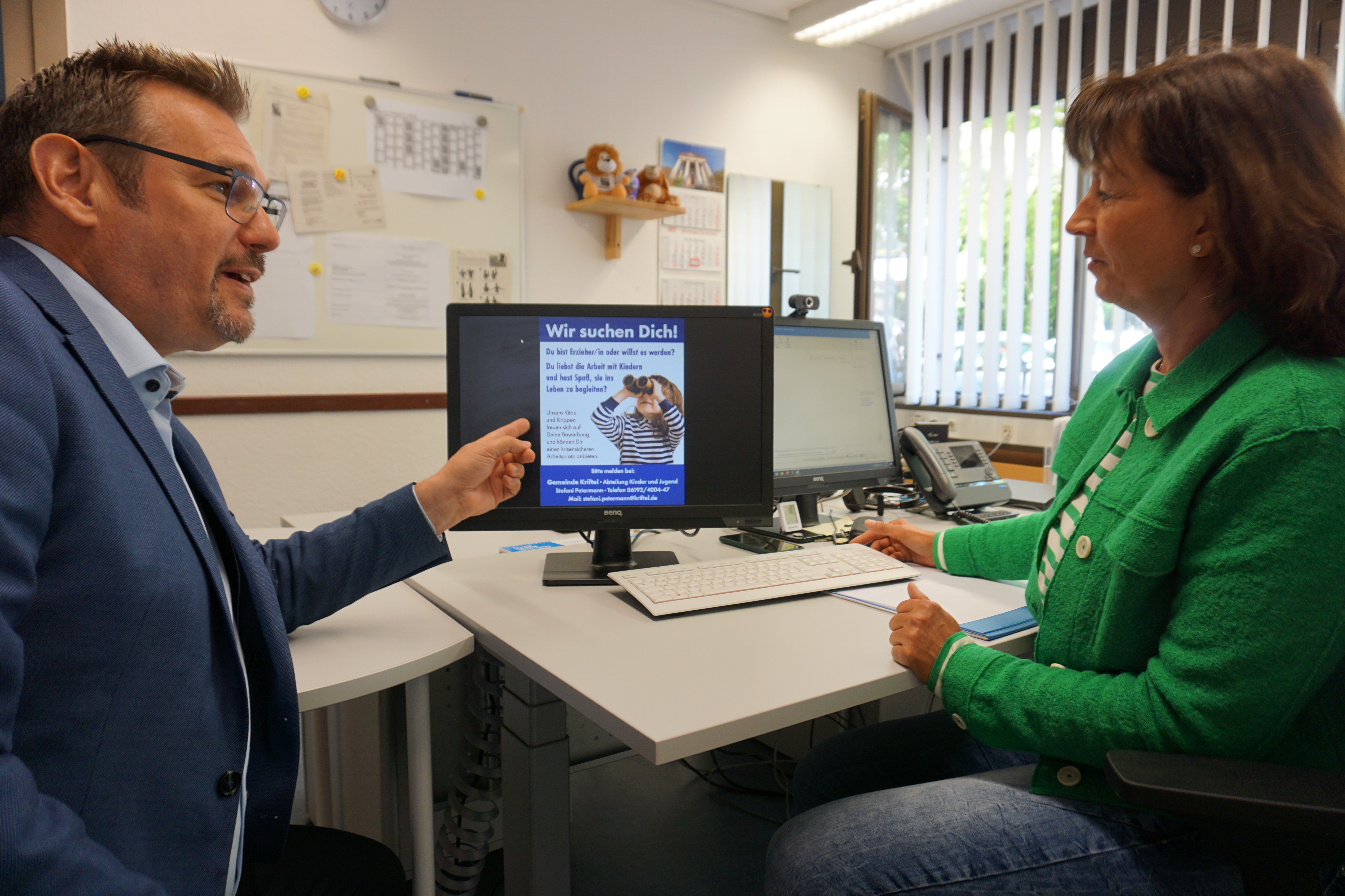 Seitz und Petermann diskutieren über Anzeigenentwurf.