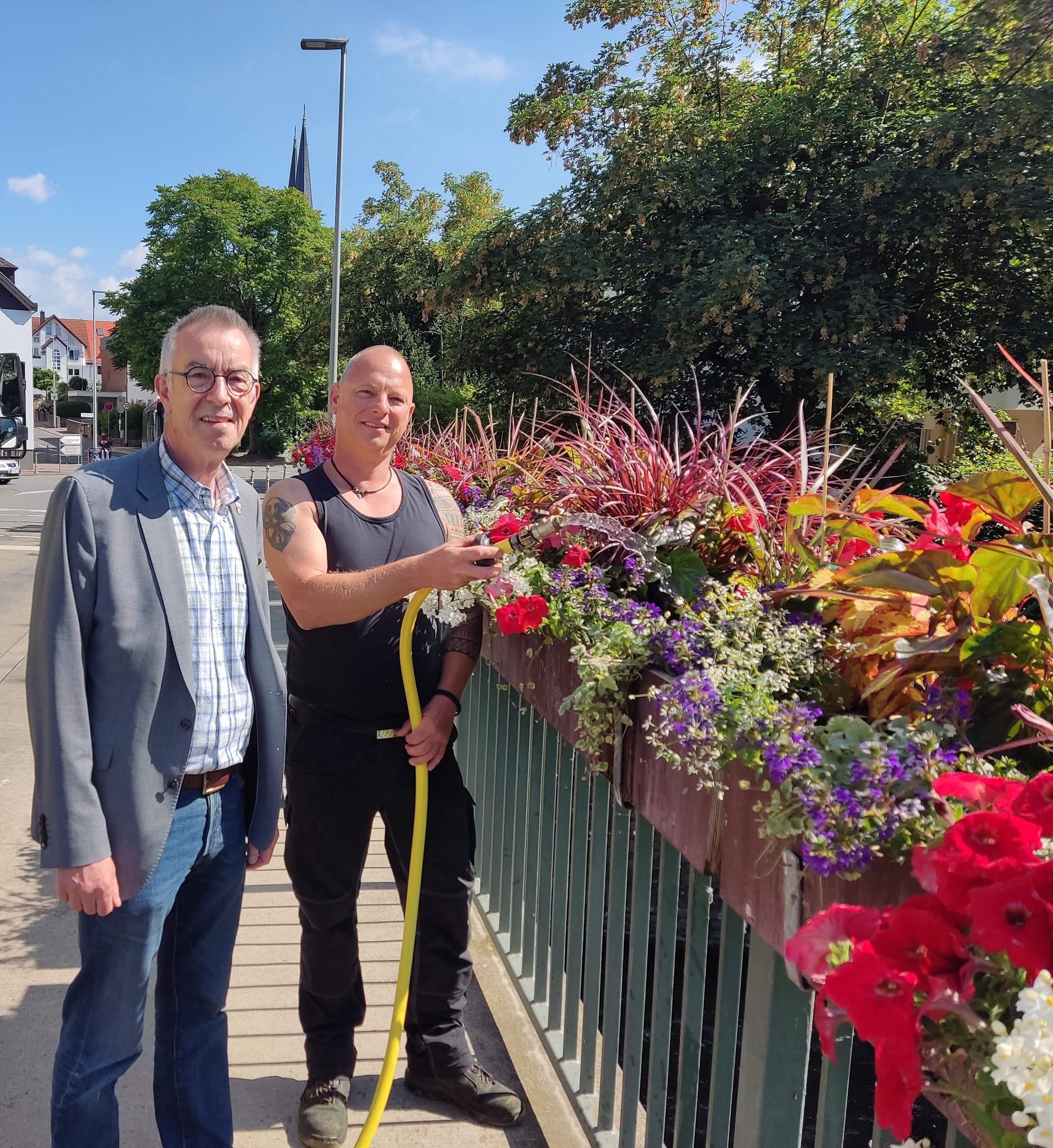 Jirasek und Tänzer an den neubepflanzten Blumenkästen.