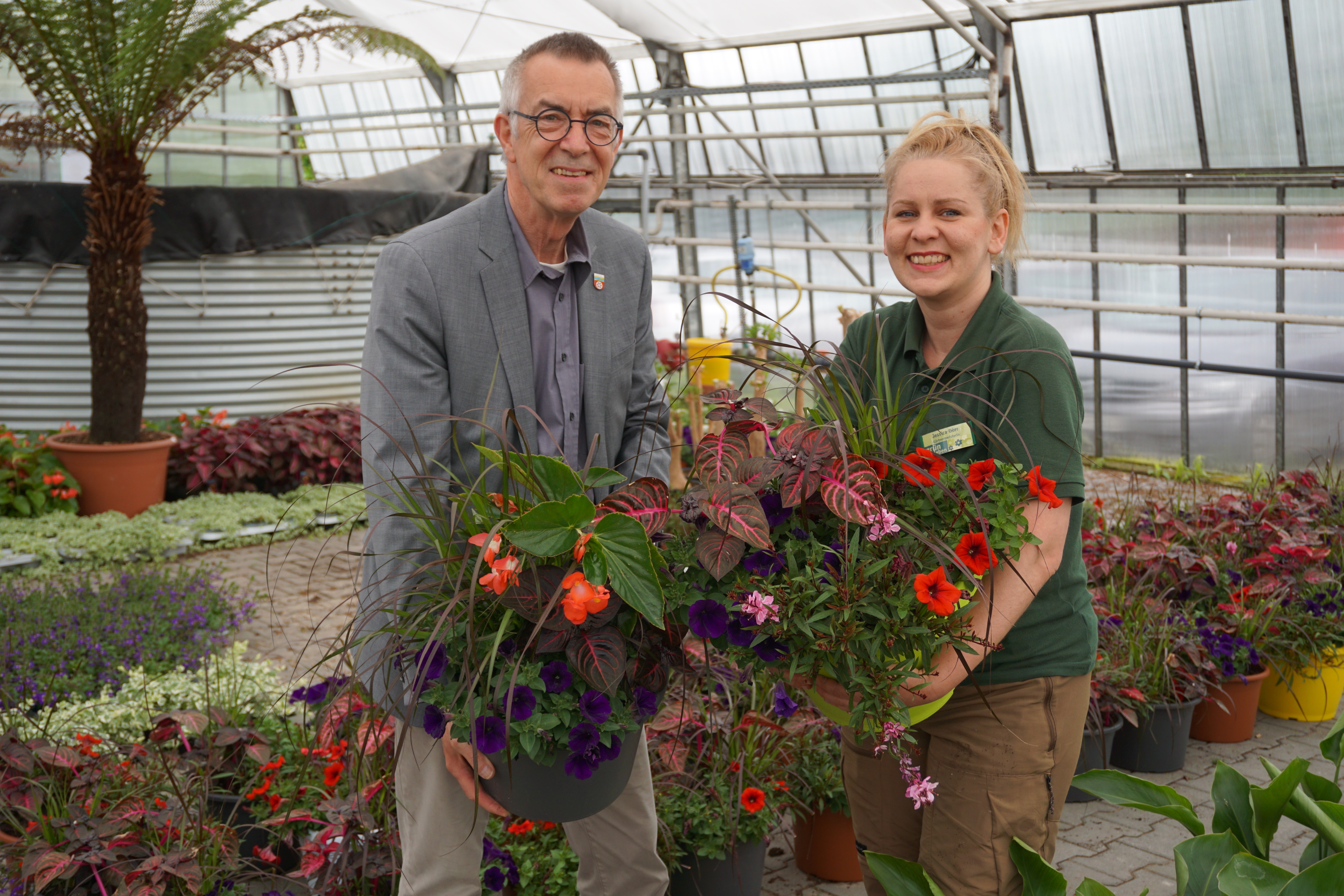 Jirasek und Gärtnermeisterin zwischen Pflanztöpfen.