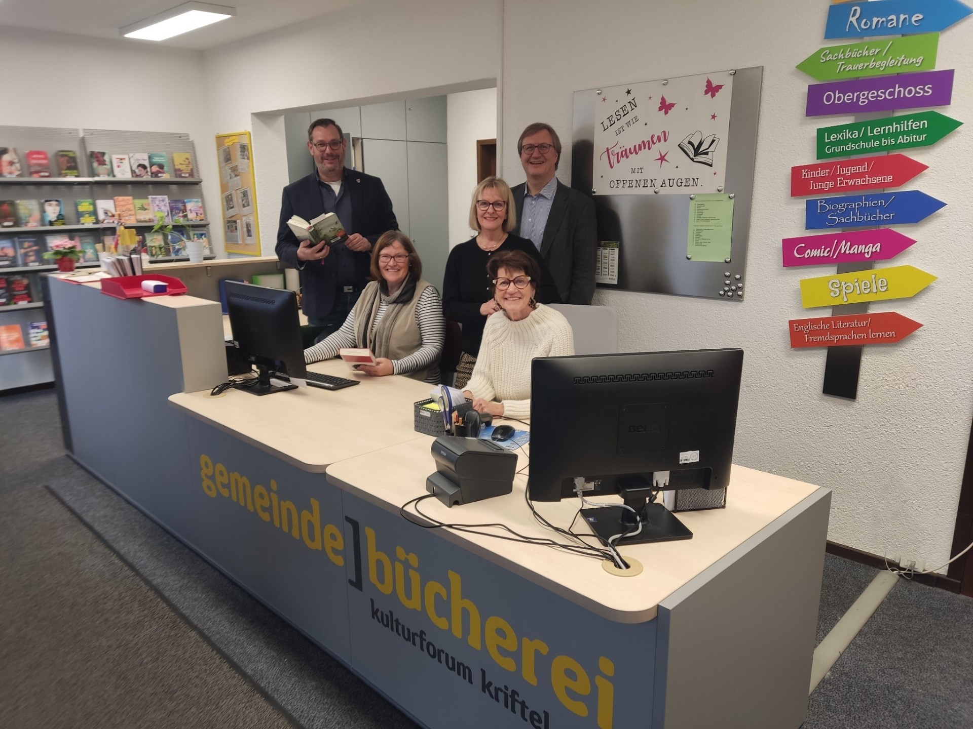 Bürgermeister und Büchereiteam hinter der neuen Theke.
