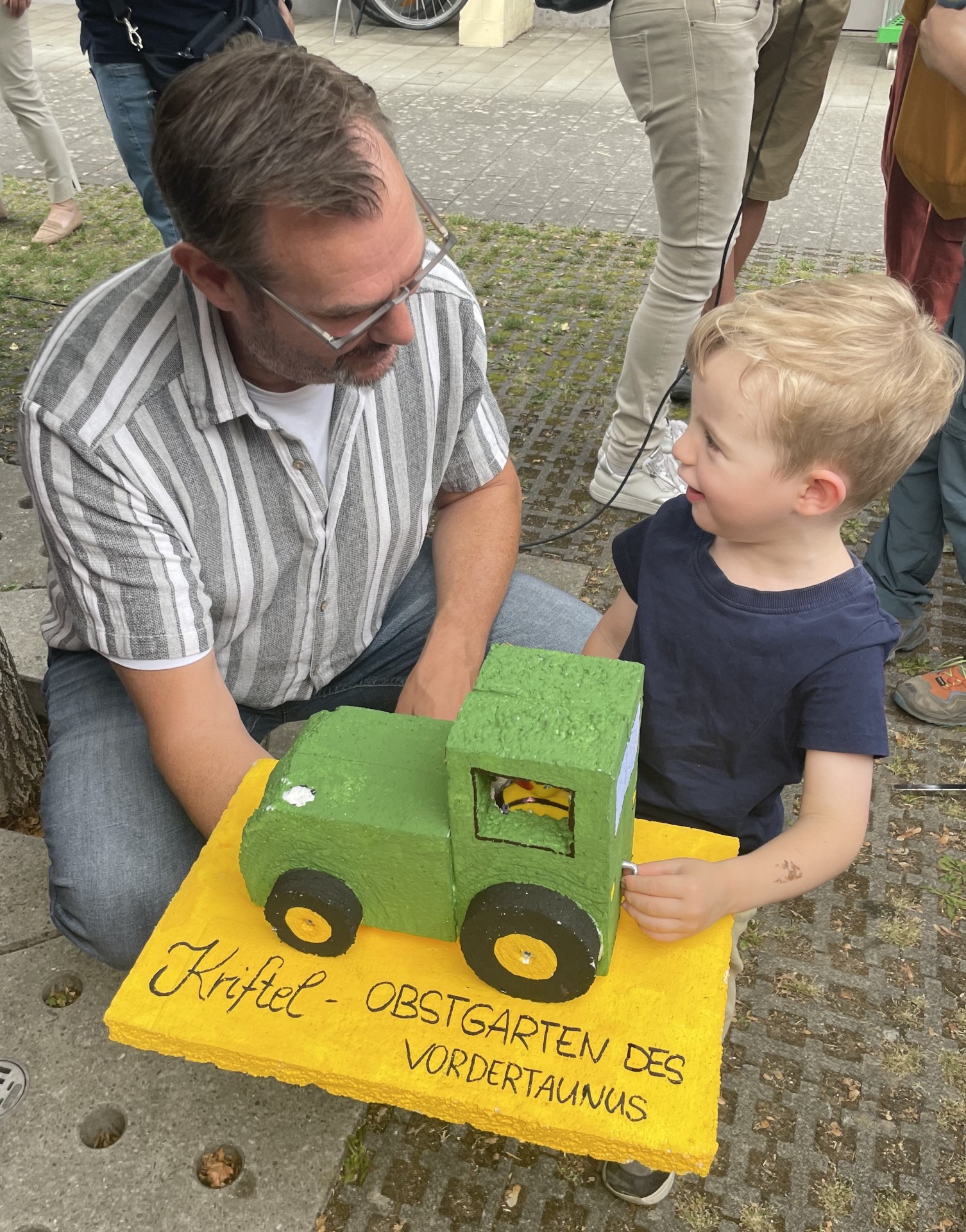 Bürgermeister mit Kind und Ente im Traktor.