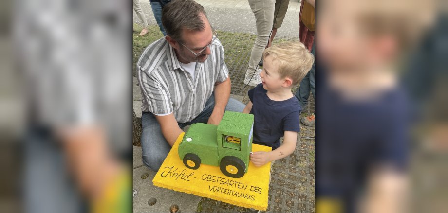 Bürgermeister mit Kind und Ente im Traktor.
