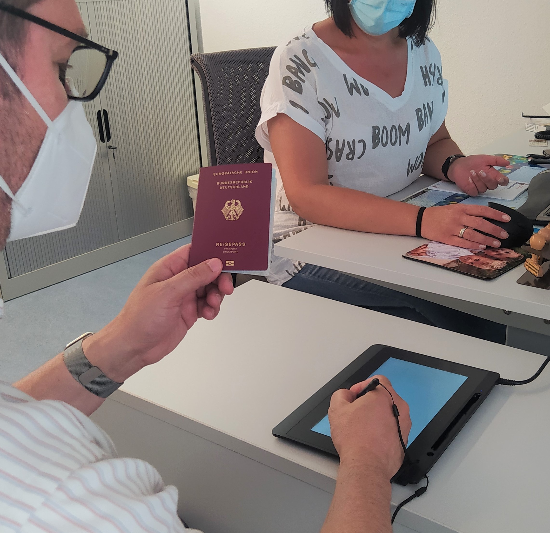 Bürgermeister Seitz mit einem Pass in der Hand am neuen Arbeitsplatz.