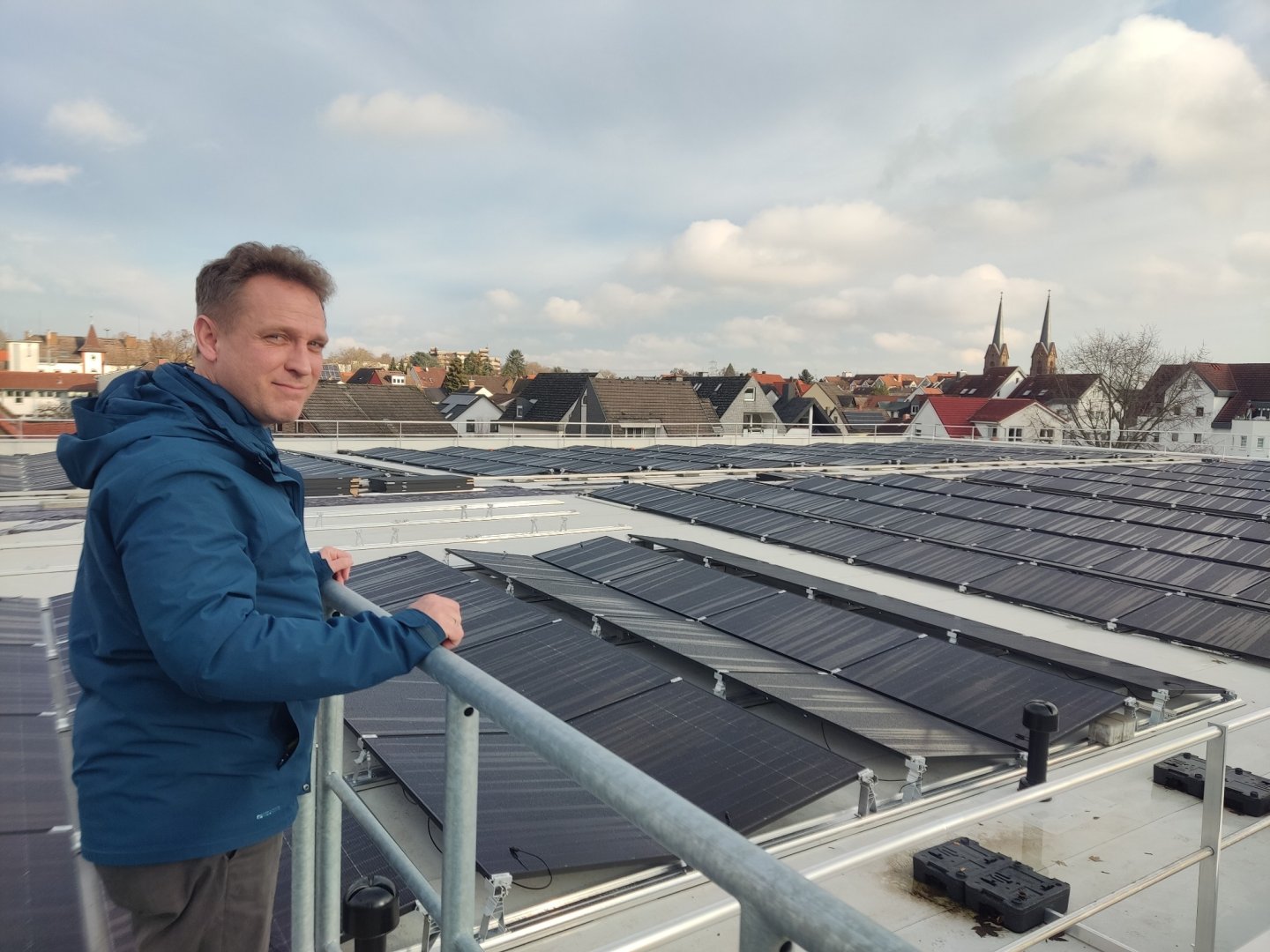 Martin Mohr auf dem Dach der Schwarzbachhalle vor den PV-Modulen.
