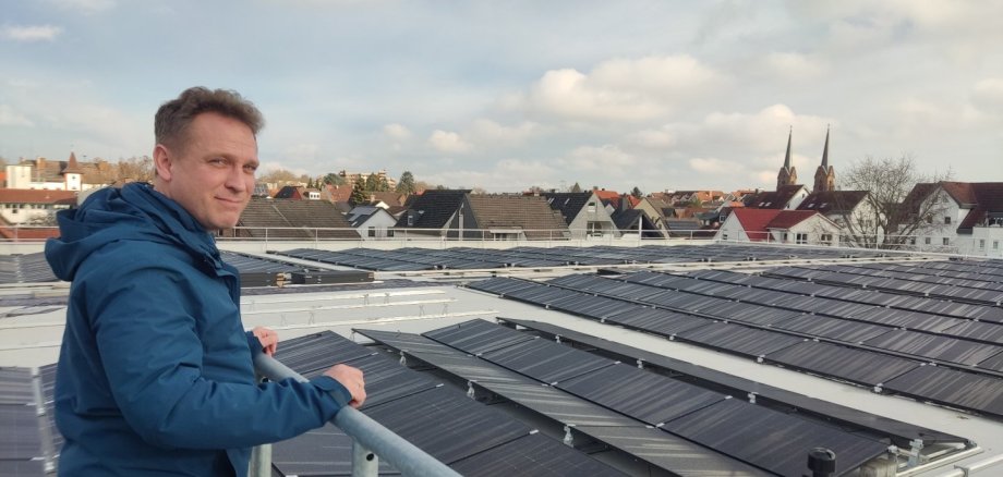 Martin Mohr auf dem Dach der Schwarzbachhalle vor den PV-Modulen.