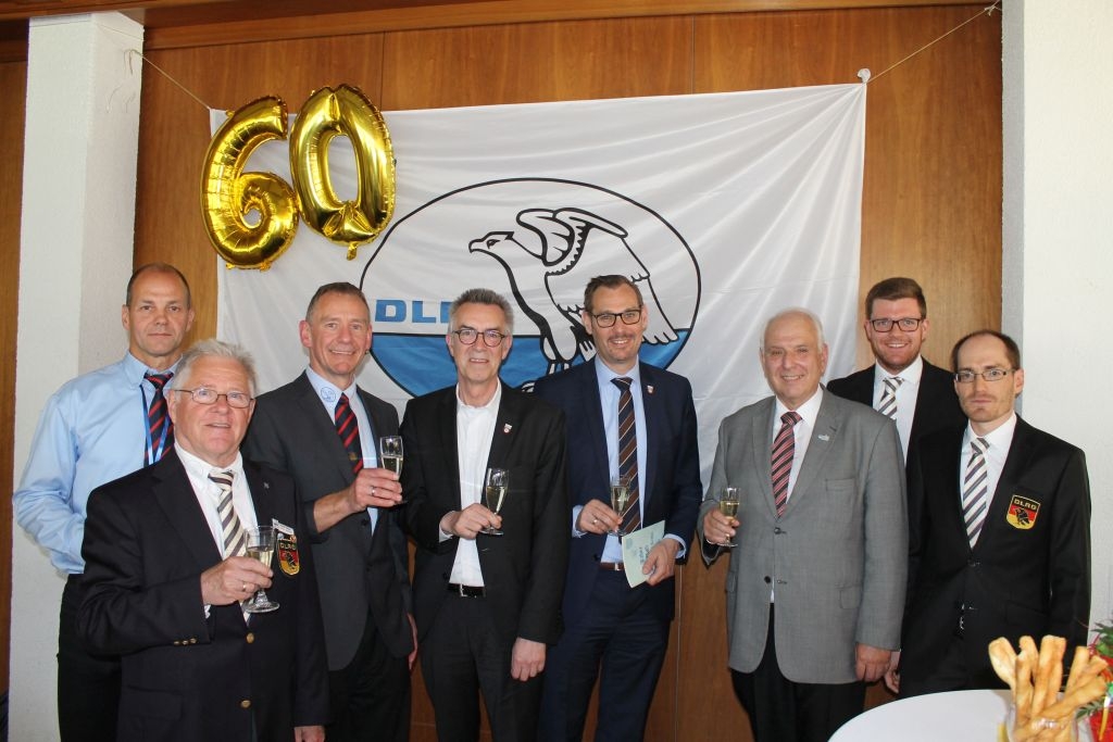 Die geladenen Promis vor dem DLRG-Logo mit einem Luftballon in Form einer 60.