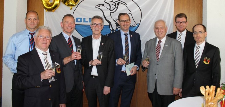 Die geladenen Promis vor dem DLRG-Logo mit einem Luftballon in Form einer 60.