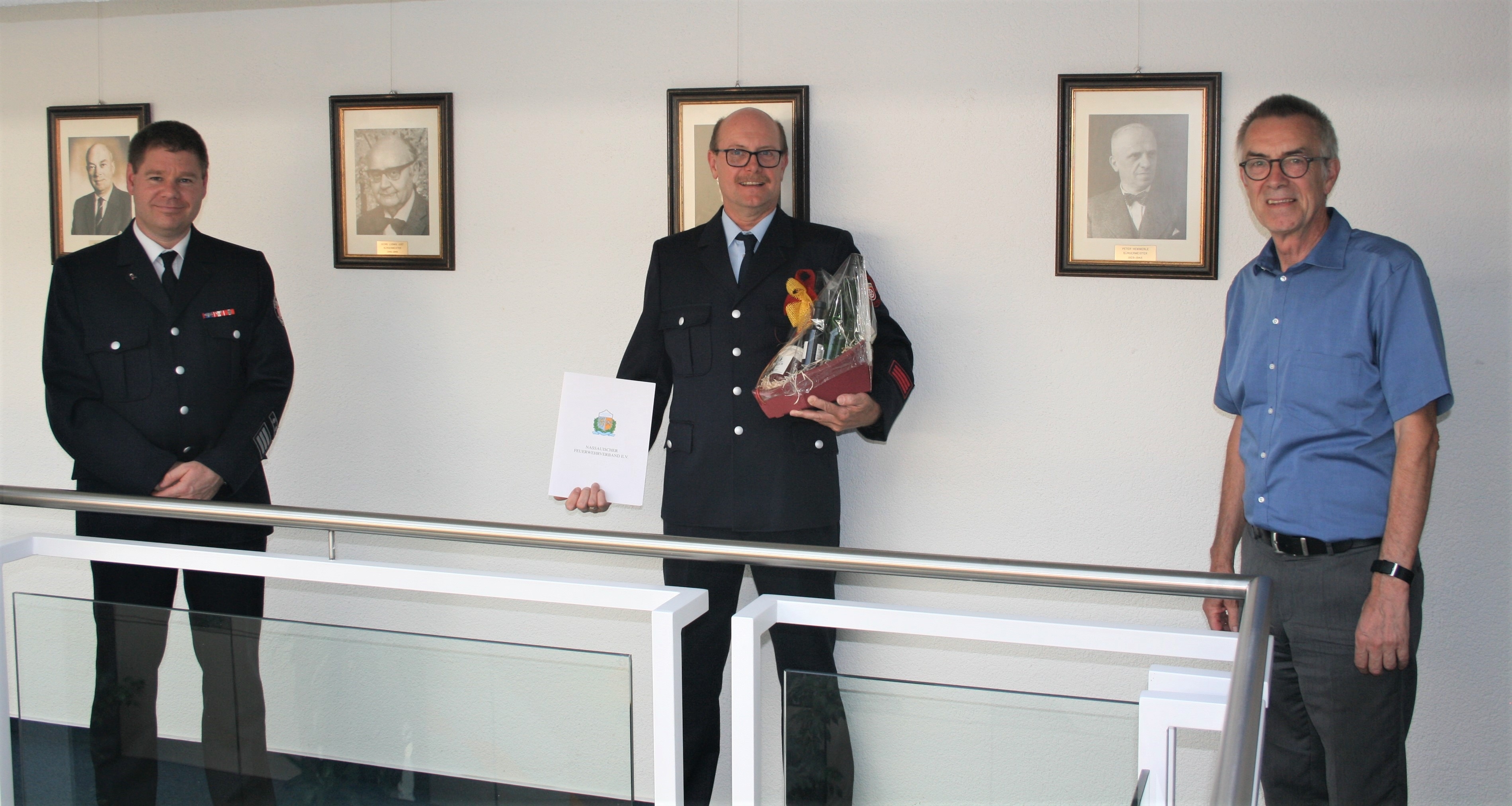 Harald Burg mit Urkunde und Geschenk zwischen Gemeindebrandinspektor Kilian und Erstem Beigeordneten Jirasek.